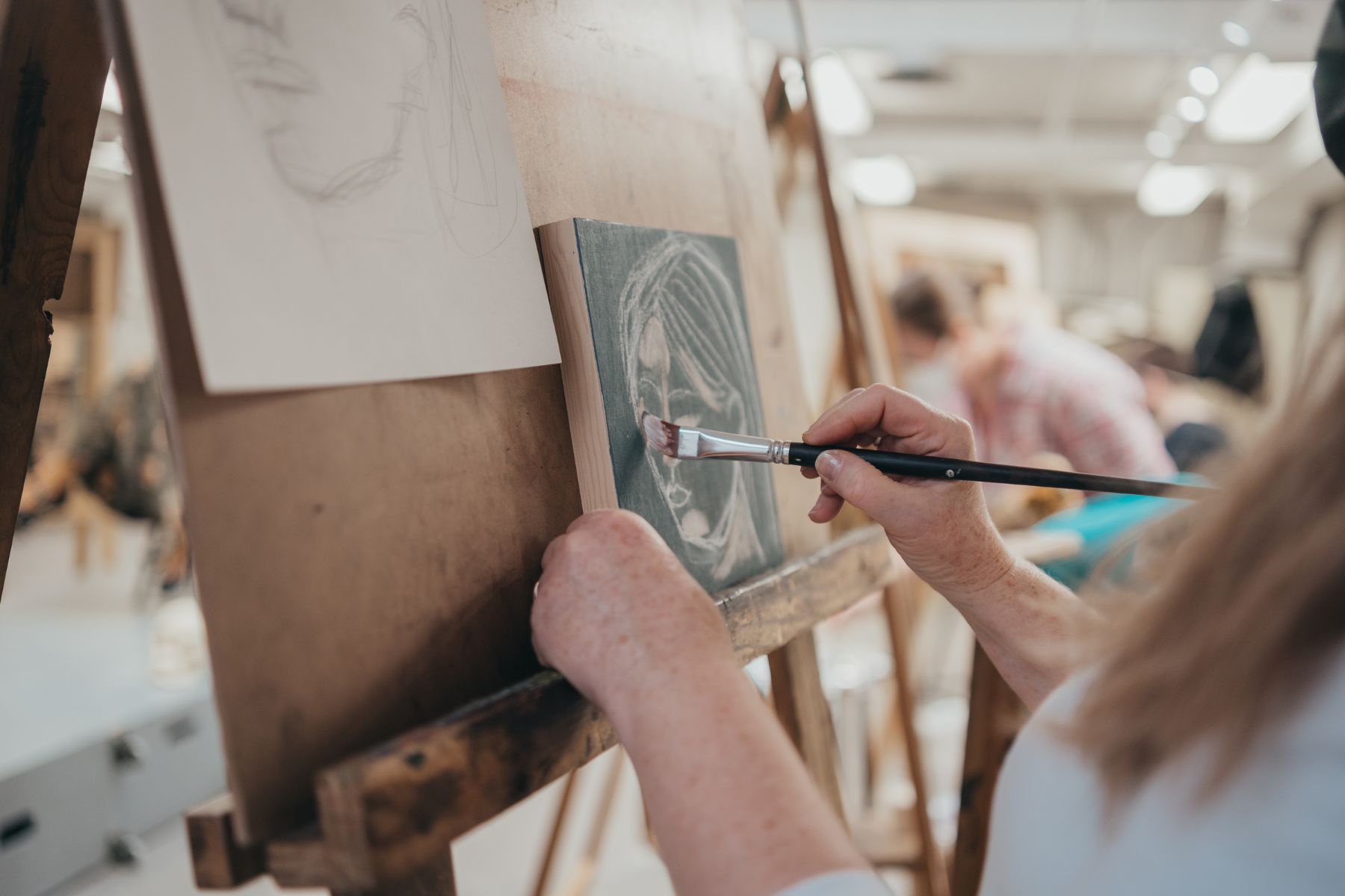 A person painting with acrylics at Honeybee Folk School in Fredericton, New Brunswick.